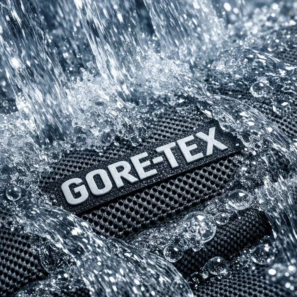 An extreme macro shot of water cascading over a Gore-Tex membrane surface during a high-speed rinse cycle. Detailed fluid dynamics, crystal clear water, high-tech engineering aesthetic, clinical lighting, 8k.
